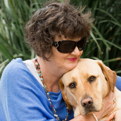 Photo of Nina Smith hugging her golden Labrador Guide Dog Nixon